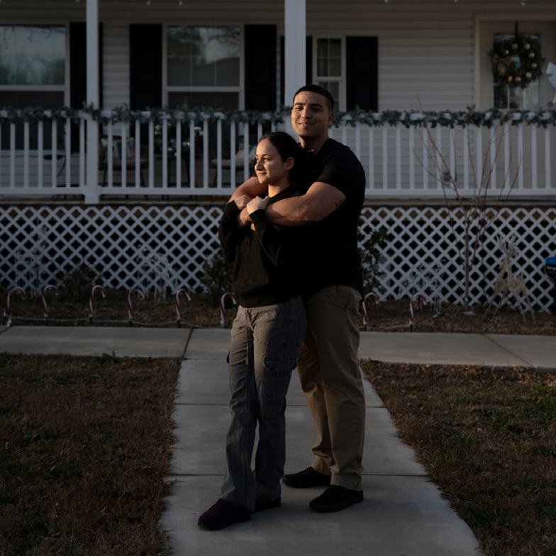 A young couple standing in front of their new factory-built home.